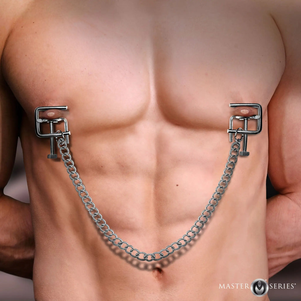 Master Series silver metal pressure vice nipple clamps connected by a link chain on a man's bare chest.