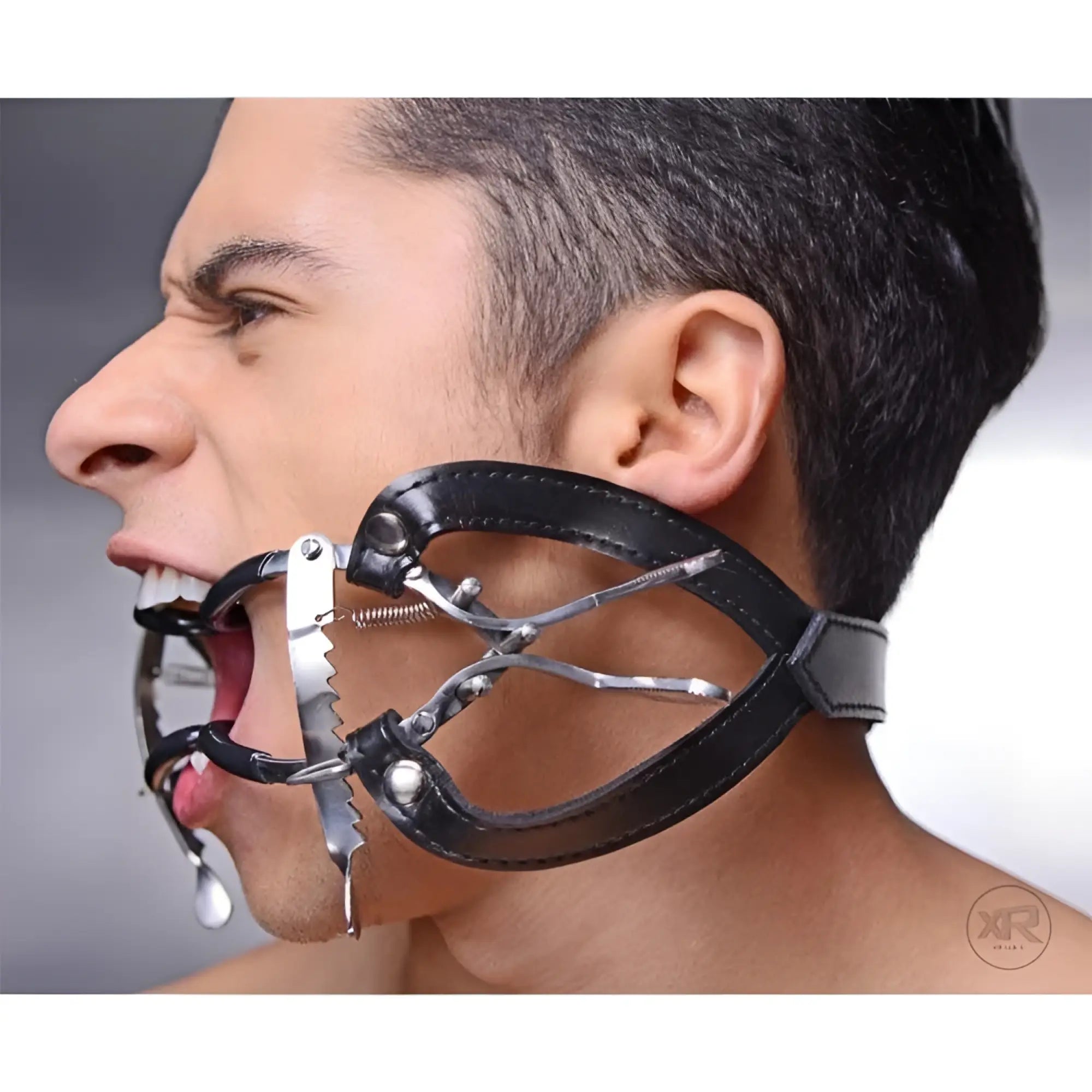 Master Series Ratchet Style Jennings Mouth Gag: Silver metal, serrated design with adjustable black leather head strap.