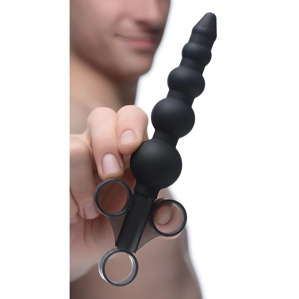 Master Series black silicone graduated beads lubricant launcher held by a hand, featuring a three-ring syringe handle.
