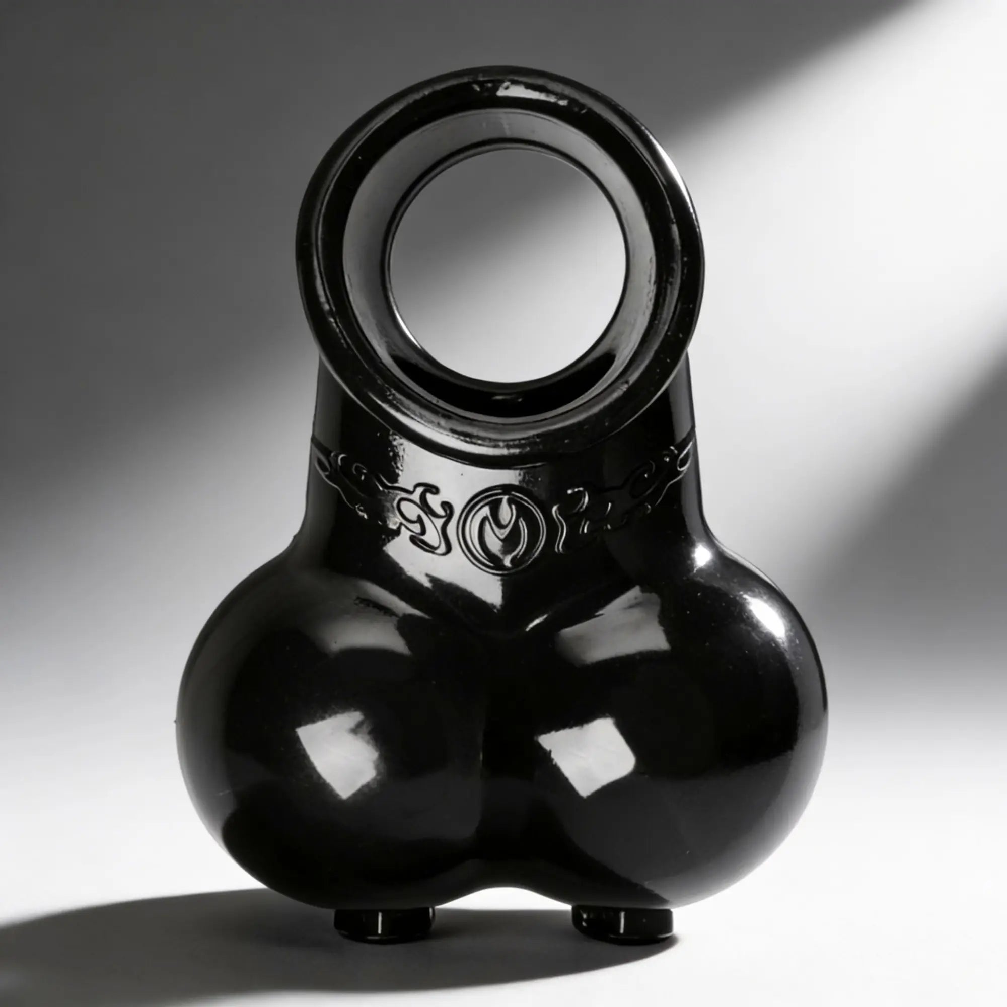 Master Series Squeeze My Sack: A glossy, black, anatomical-style silicone erection enhancer with a scrotal pouch.