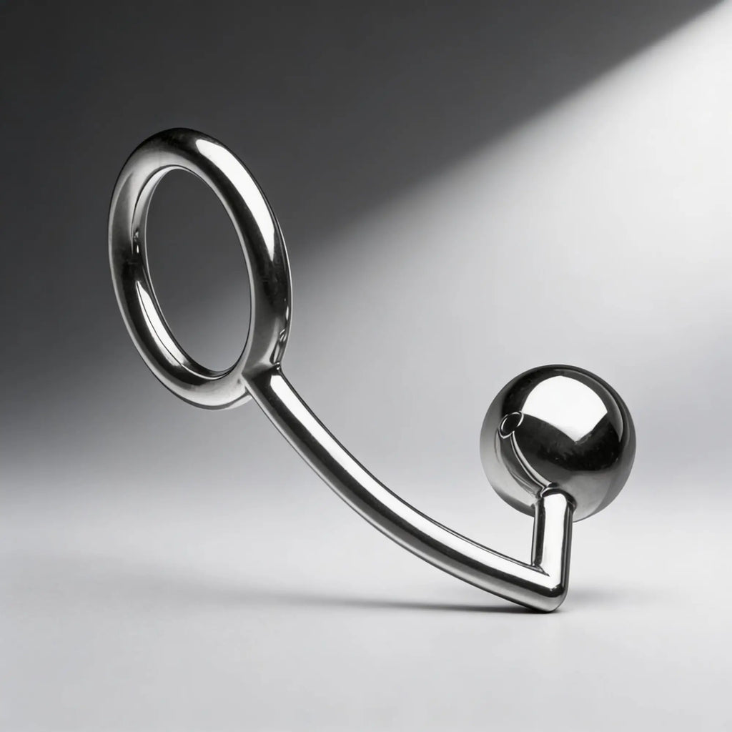 Master Series Stainless Steel Intruder Cock Ring: A polished silver metal ring connected to a smooth sphere.