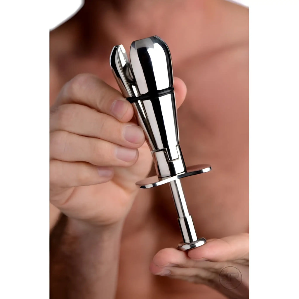 Master Series Stainless Steel Locking Anal Plug: a silver, metallic, adjustable-tip plug held in person's hands.
