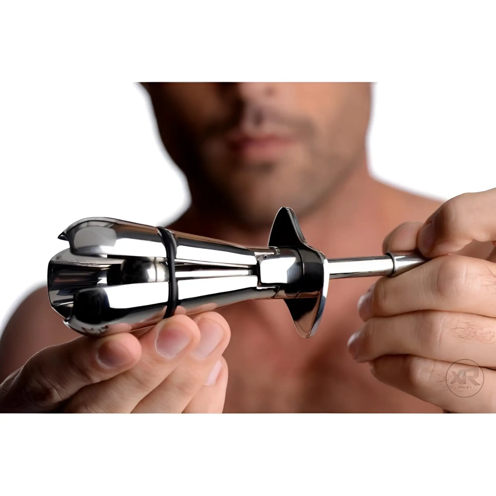 Hands holding a polished, silver Master Series Stainless Steel Locking Anal Plug with an expandable flower-petal design.