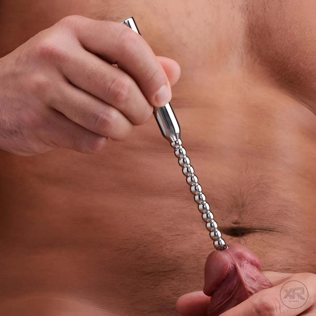 Master Series stainless steel beaded vibrating urethral sound being held against a penis.