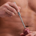 Master Series stainless steel beaded vibrating urethral sound being held against a penis.