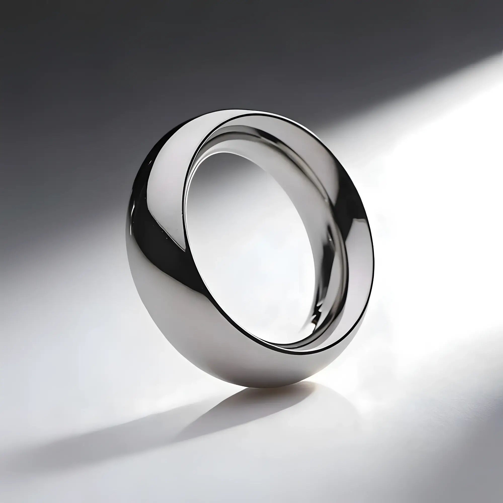 Master Series Steel Donut Cock Ring: a smooth, polished silver-toned metal ring angled on a light grey background.