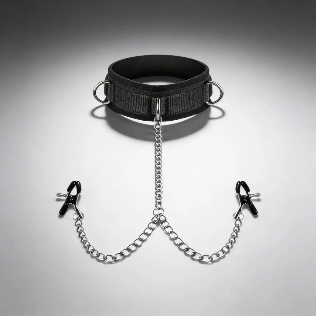 Master Series black collar with metal rings, attached via silver chains to two black-tipped nipple clamps.