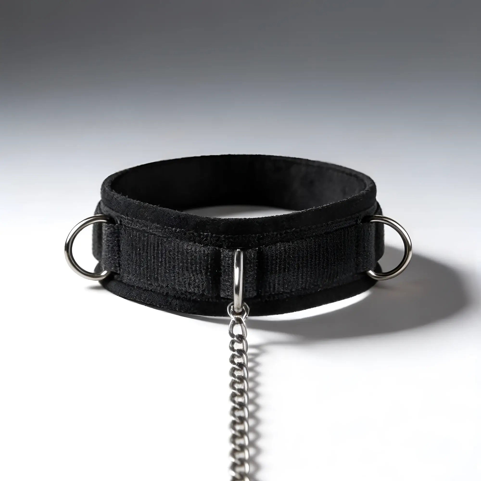 Black Master Series Submission collar with three silver metal D-rings and an attached silver chain.