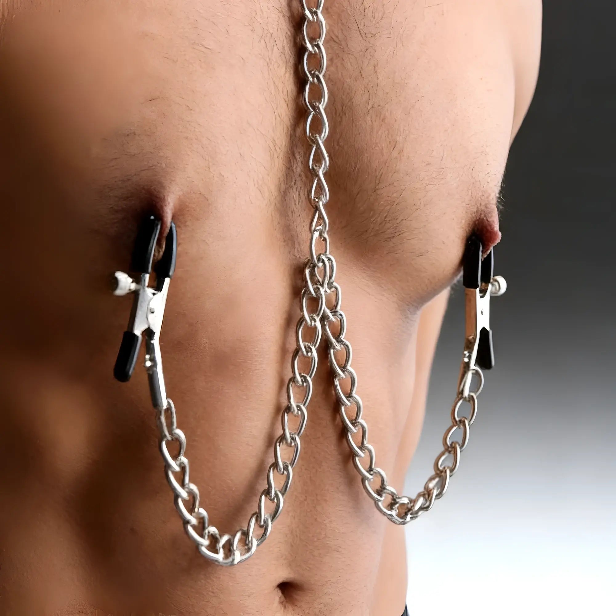 Master Series Submission Collar and silver nipple clamps with black rubber tips connected by a silver metal chain.