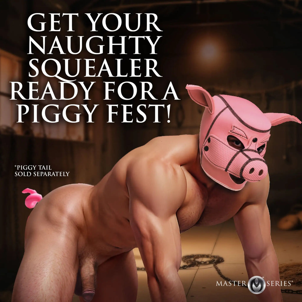 A muscular man wears a pink Master Series Swine Pig neoprene hood while on all fours in a rustic setting.