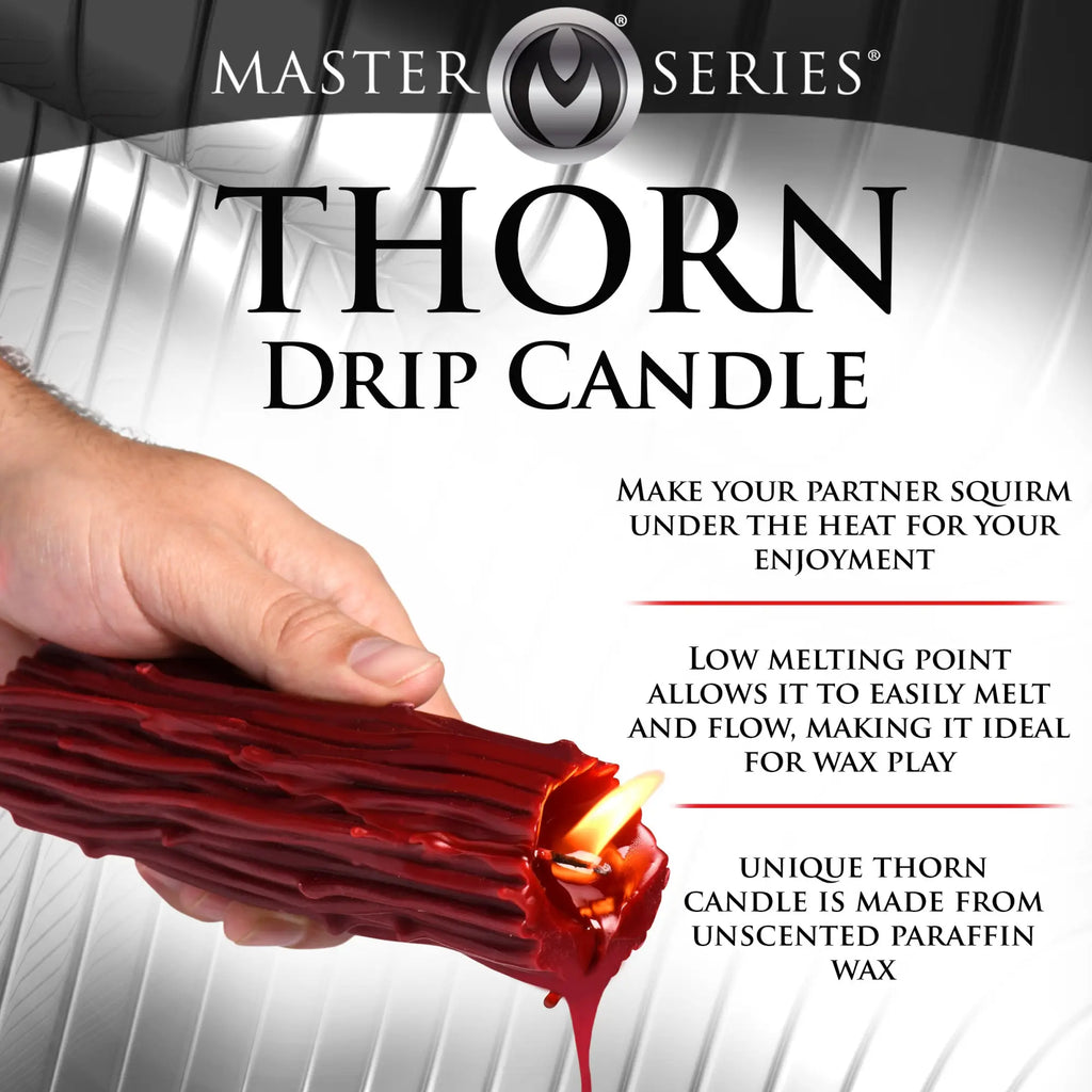 A hand holds a textured, dark red Master Series Thorn Drip Candle with a visible flame and wax melting from the tip.