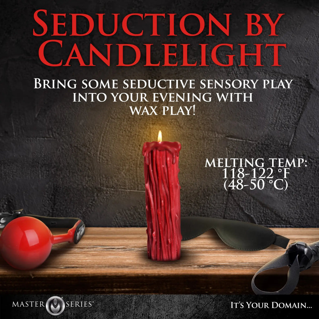 Master Series Thorn Drip Candle: A glowing red wax candle with a textured, drippy design on a wooden table.