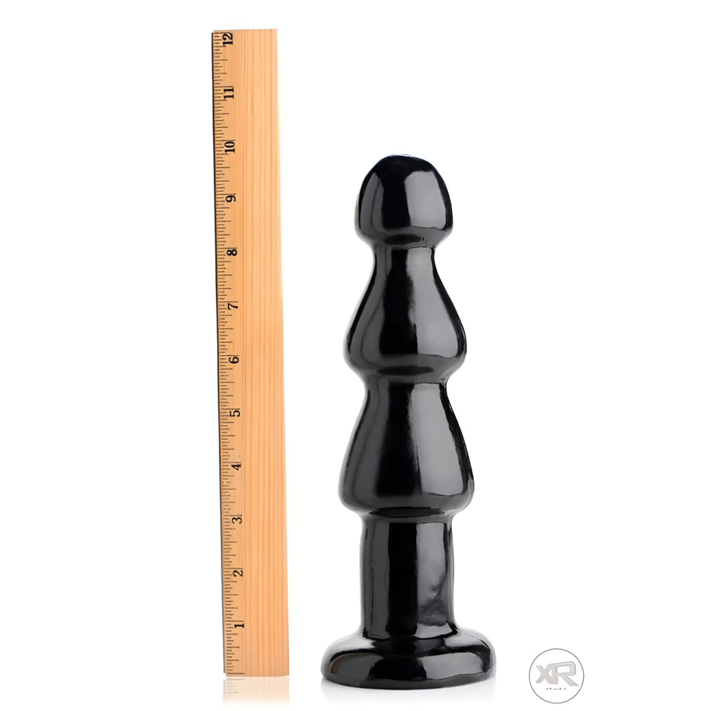 Master Series Three Bumps for Your Rump anal plug in glossy black standing next to a wooden ruler for scale.