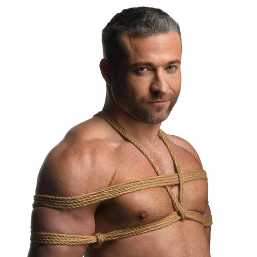A shirtless man wearing natural-colored Master Series Tied Up Jute Bondage Rope in a harness-style design.