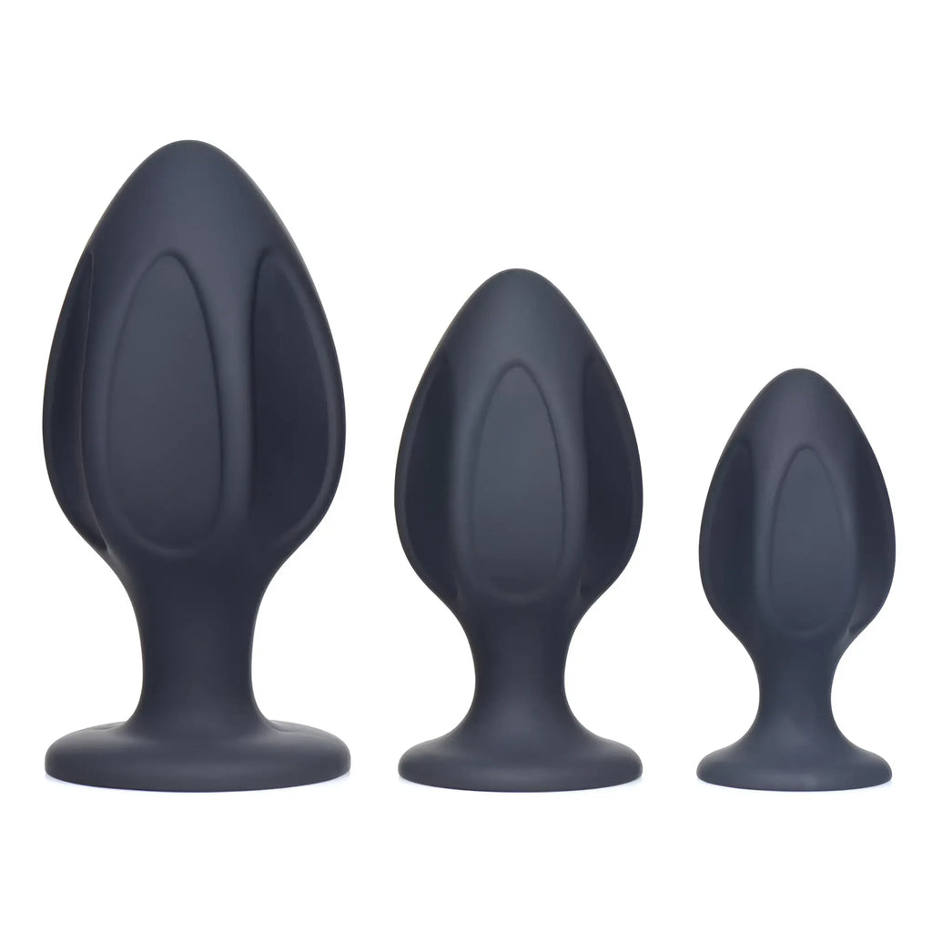 Master Series Triple Juicers: Three charcoal-grey silicone anal trainers of graduated sizes with ribbed, flared bases.