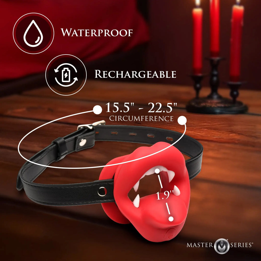 Master Series Vampire Vibrating Mouth Gag: red silicone lips with white fangs attached to an adjustable black strap.