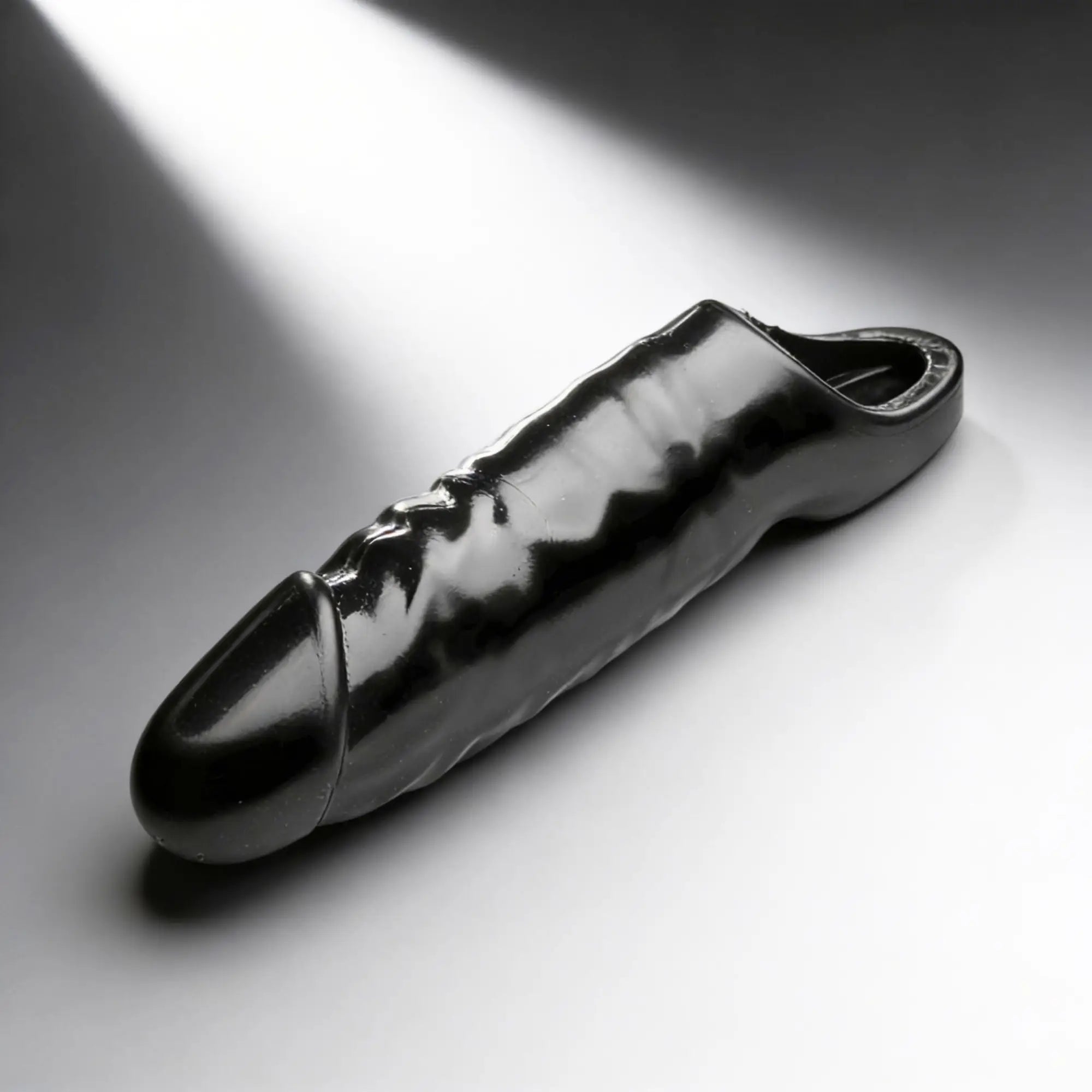 Master Series XL Black Mamba cock sheath: a sleek, shiny black, textured phallic sleeve on a grey background.