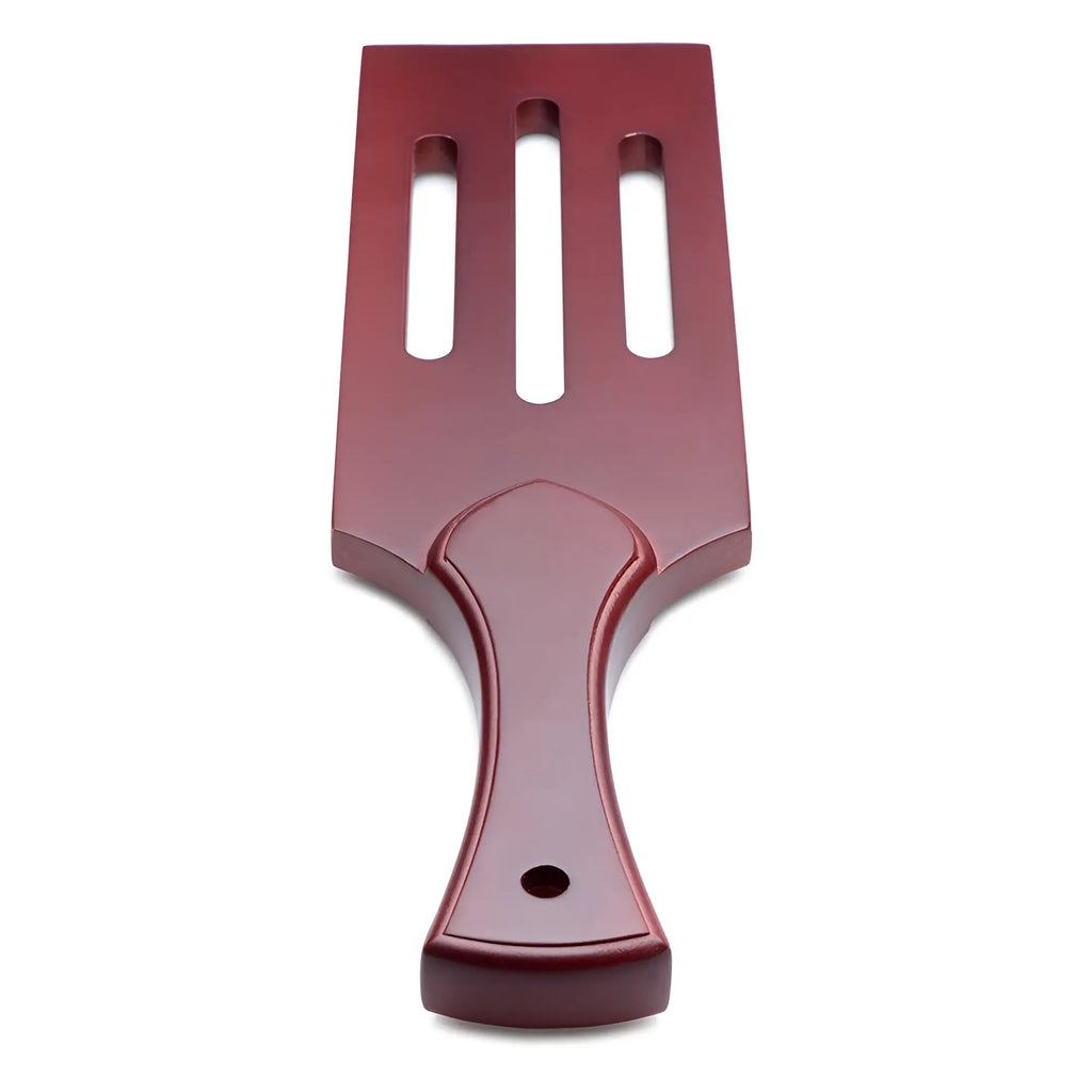 Red plastic spatula with three vertical slots and contoured handle in masters wooden paddle product design