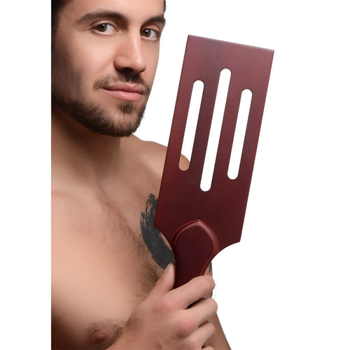 A sleek dark red wooden spatula with three elongated slots and a rounded handle from Masters Wooden Paddle