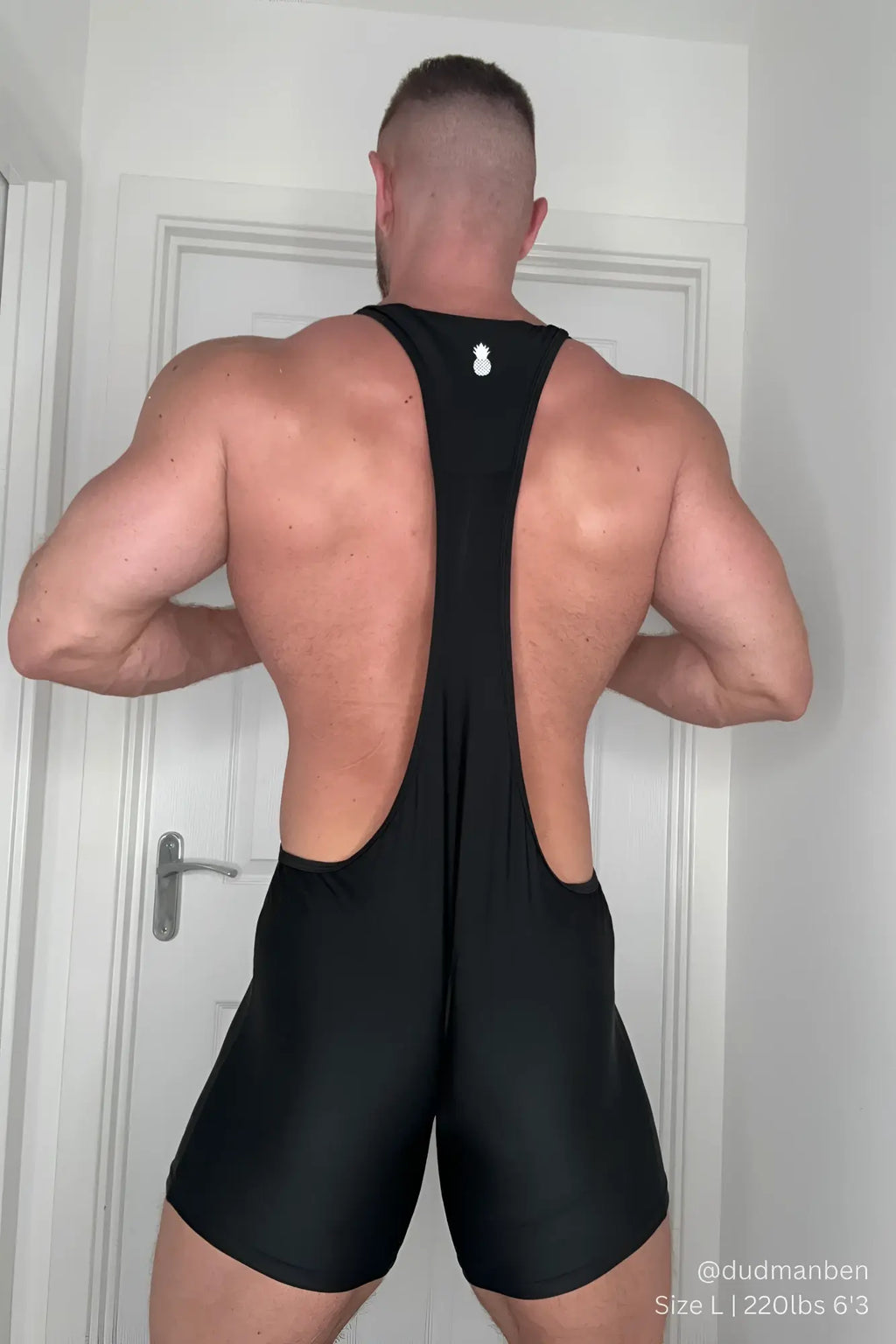 Back view of men’s athletic wrestling singlet bodysuit obsidian in black with form-fitting fabric and small white logo