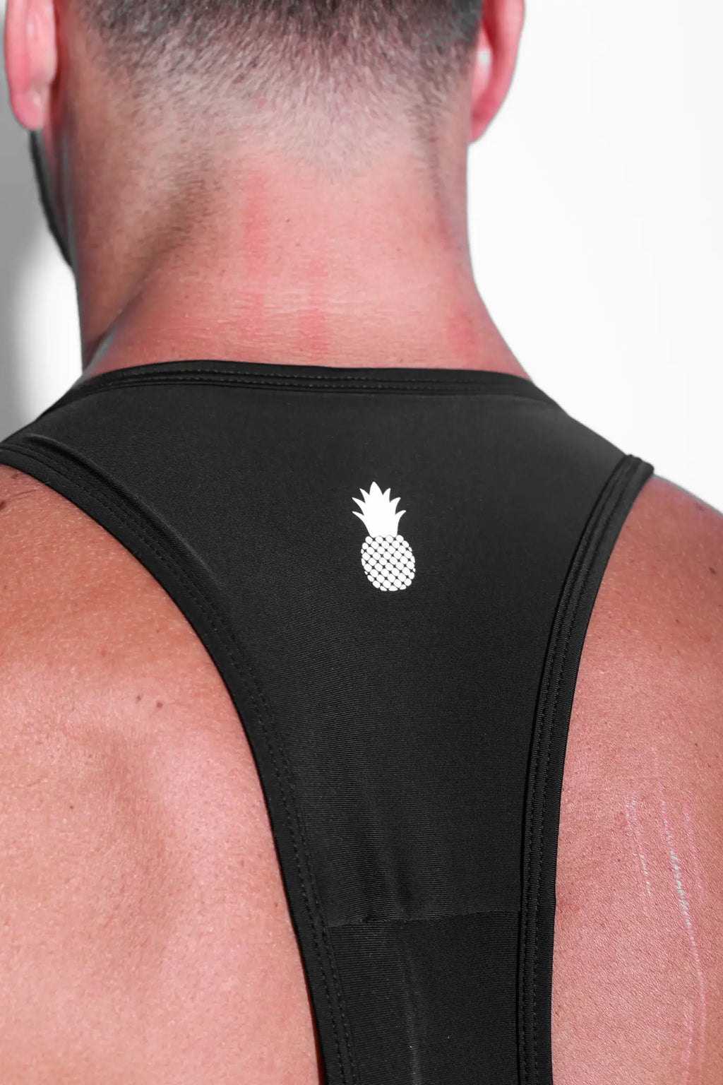 Back view of men’s athletic wrestling singlet bodysuit obsidian in black with white pineapple logo on back