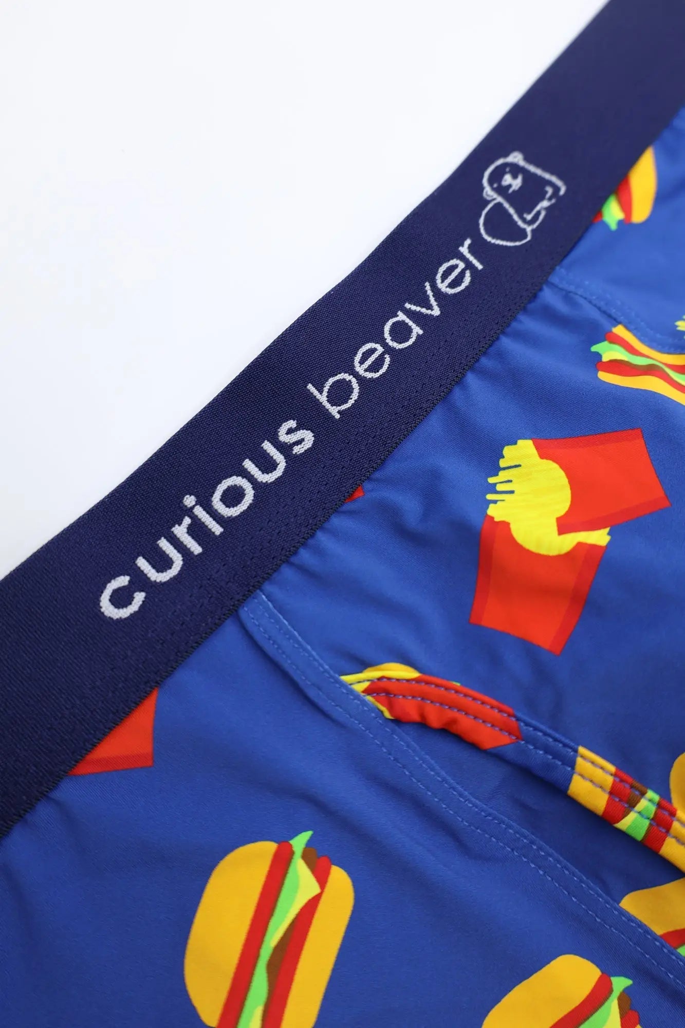 Men’s blue boxer briefs with playful fast-food print of hot dogs fries and burgers and navy curious beaver waistband