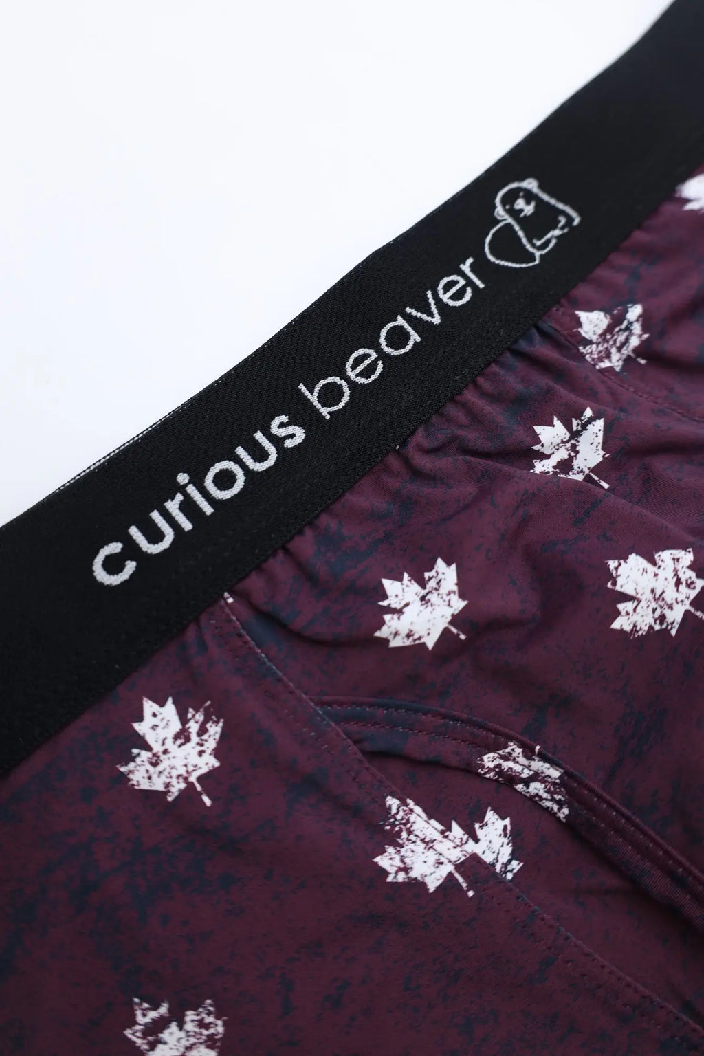 Men’s maroon boxer briefs with white maple leaf pattern and black elastic waistband featuring curious beaver brand name