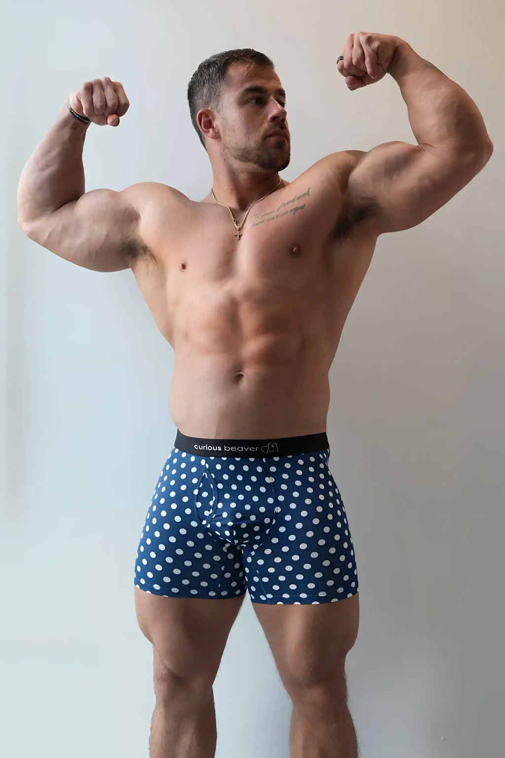 Men’s boxer briefs in blue and white polka dots with a black waistband featuring curious beaver logo
