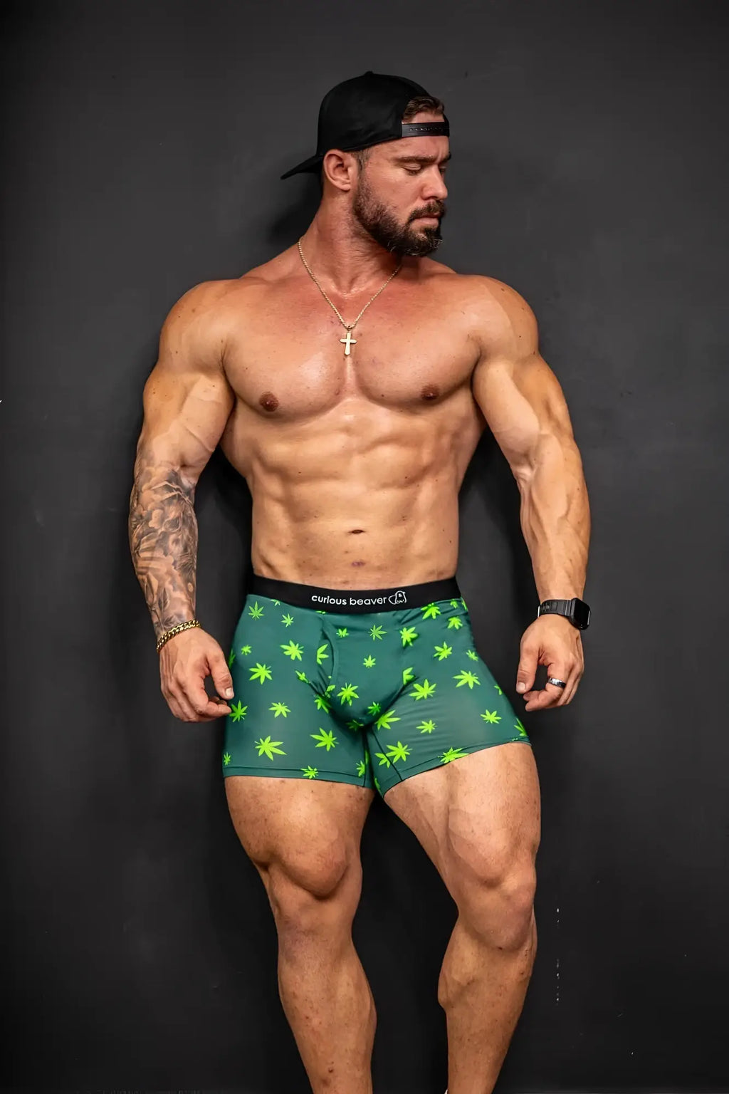 Men’s green boxer briefs with bright lime cannabis leaf pattern and black elastic waistband with curious beaver logo
