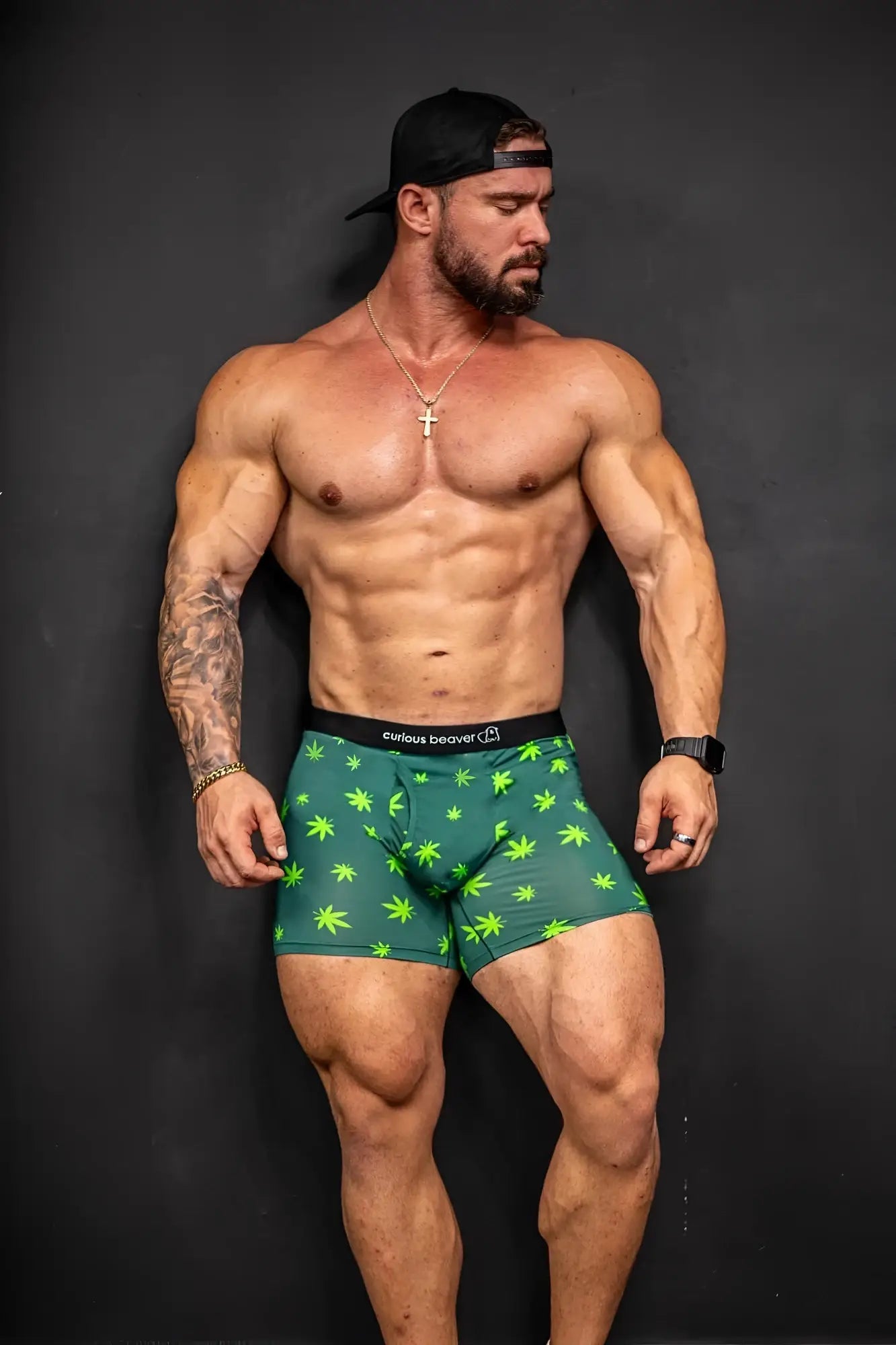 Men’s green boxer briefs with bright lime cannabis leaf pattern and black elastic waistband with curious beaver logo