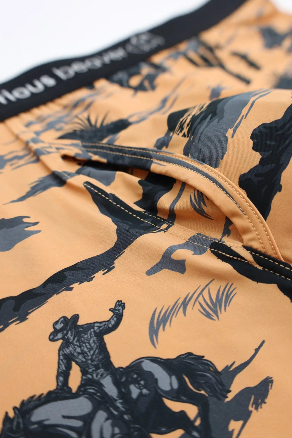 Men’s orange swim trunks with black and gray cowboy rodeo print from wild west collection