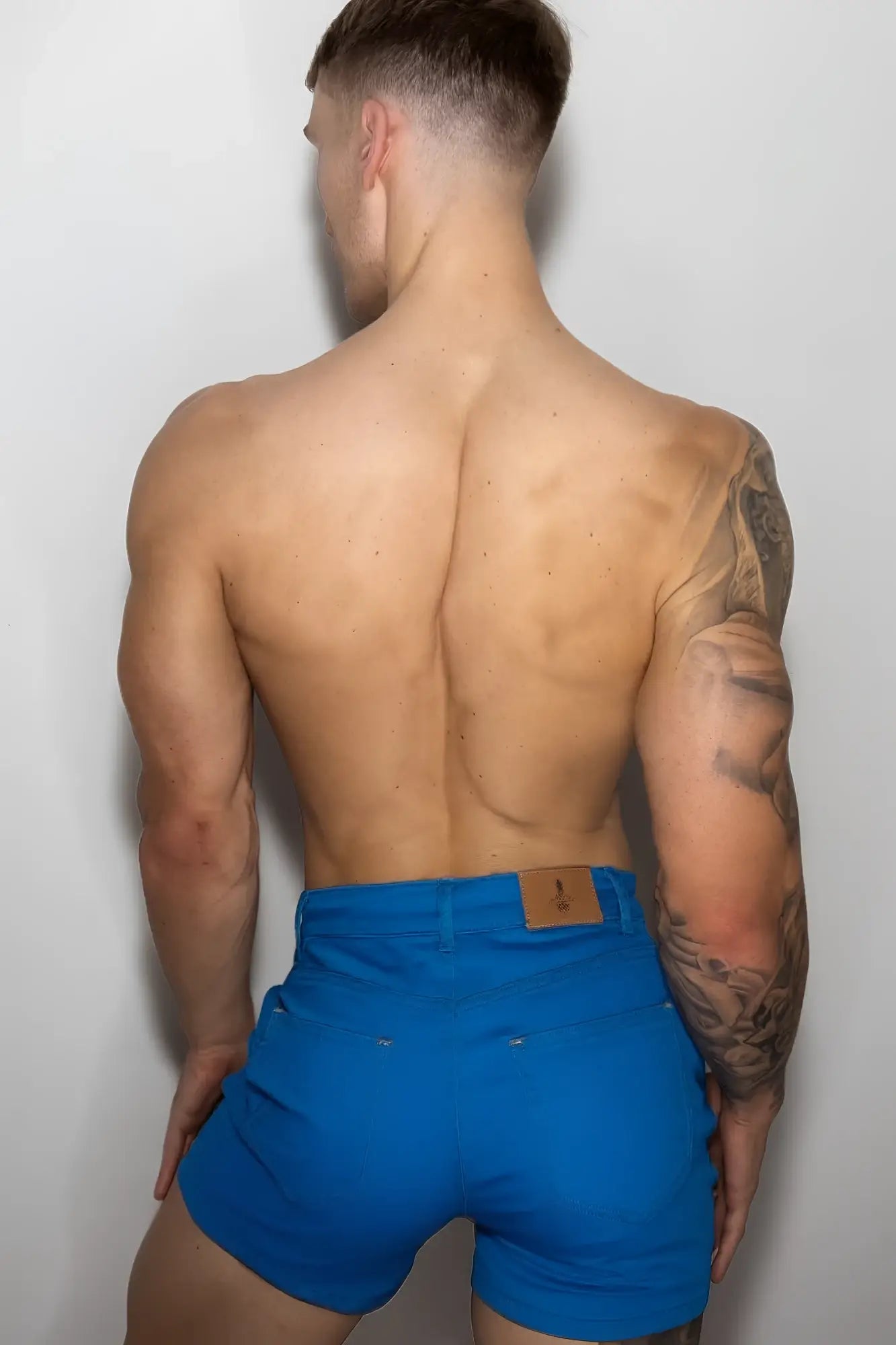 Men’s color pop 3.5 inch cyan blue denim shorts with bright blue fabric and brown leather brand patch on the waistband