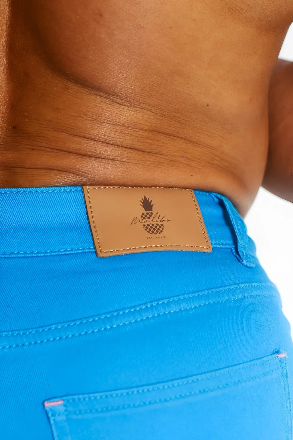 Men’s cyan blue color pop 3.5 inch denim shorts featuring bright blue denim and a tan leather patch