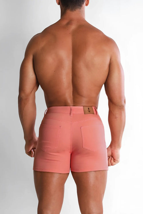 Men’s color pop hot pink fitted denim shorts with subtle back pocket design and brown leather brand patch on back waistband