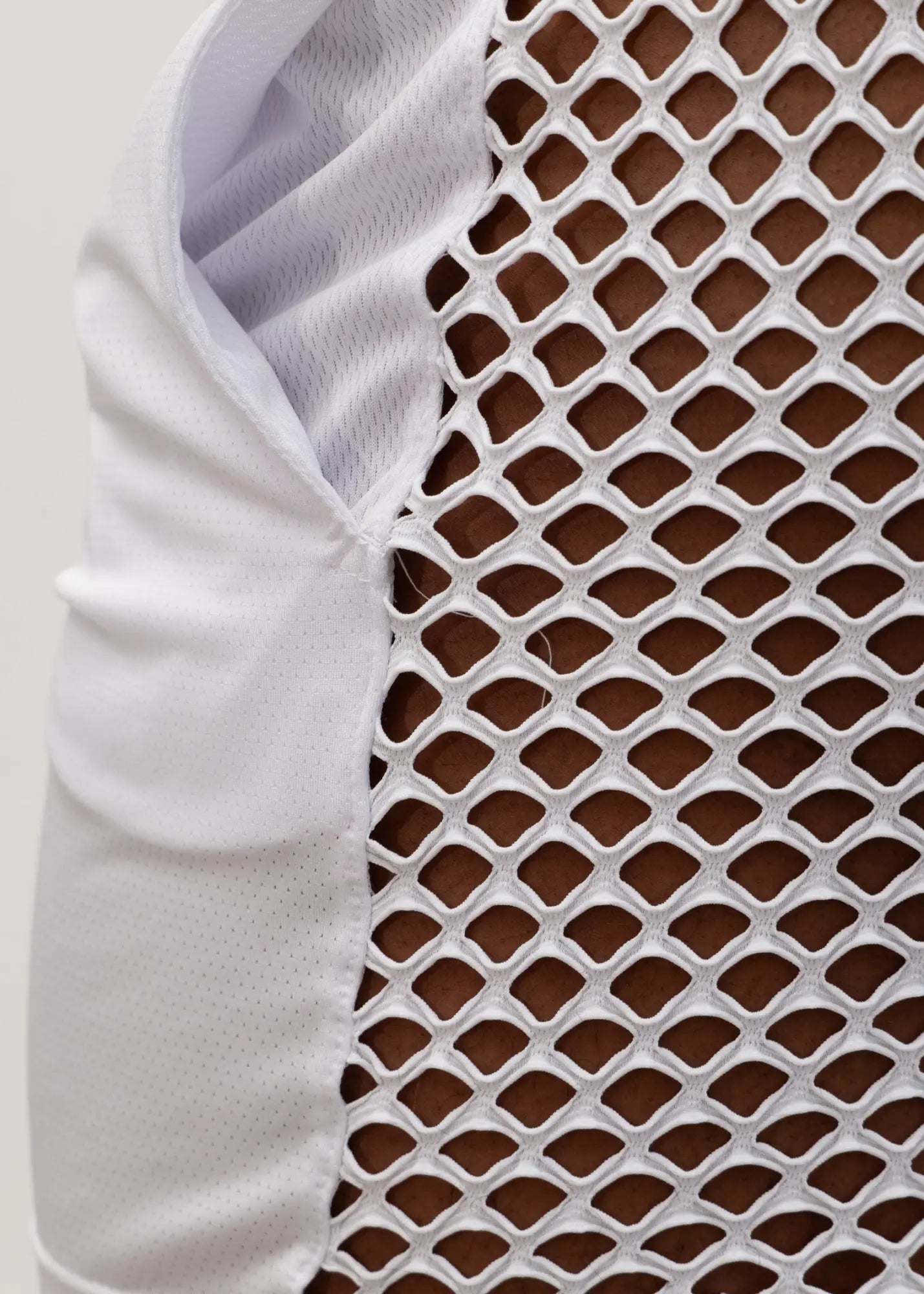 White mesh athletic vest with breathable diamond pattern and solid fabric arm panel shown from the back for mesh back short