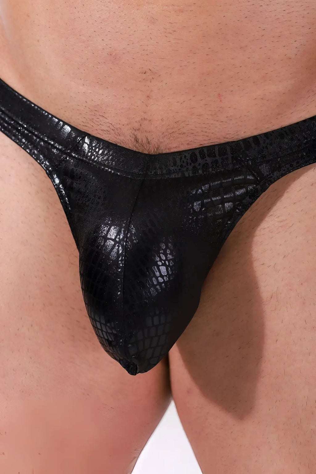 Metallica men’s midnight croc thong in black crocodile-patterned glossy material with bulge pouch visible front side