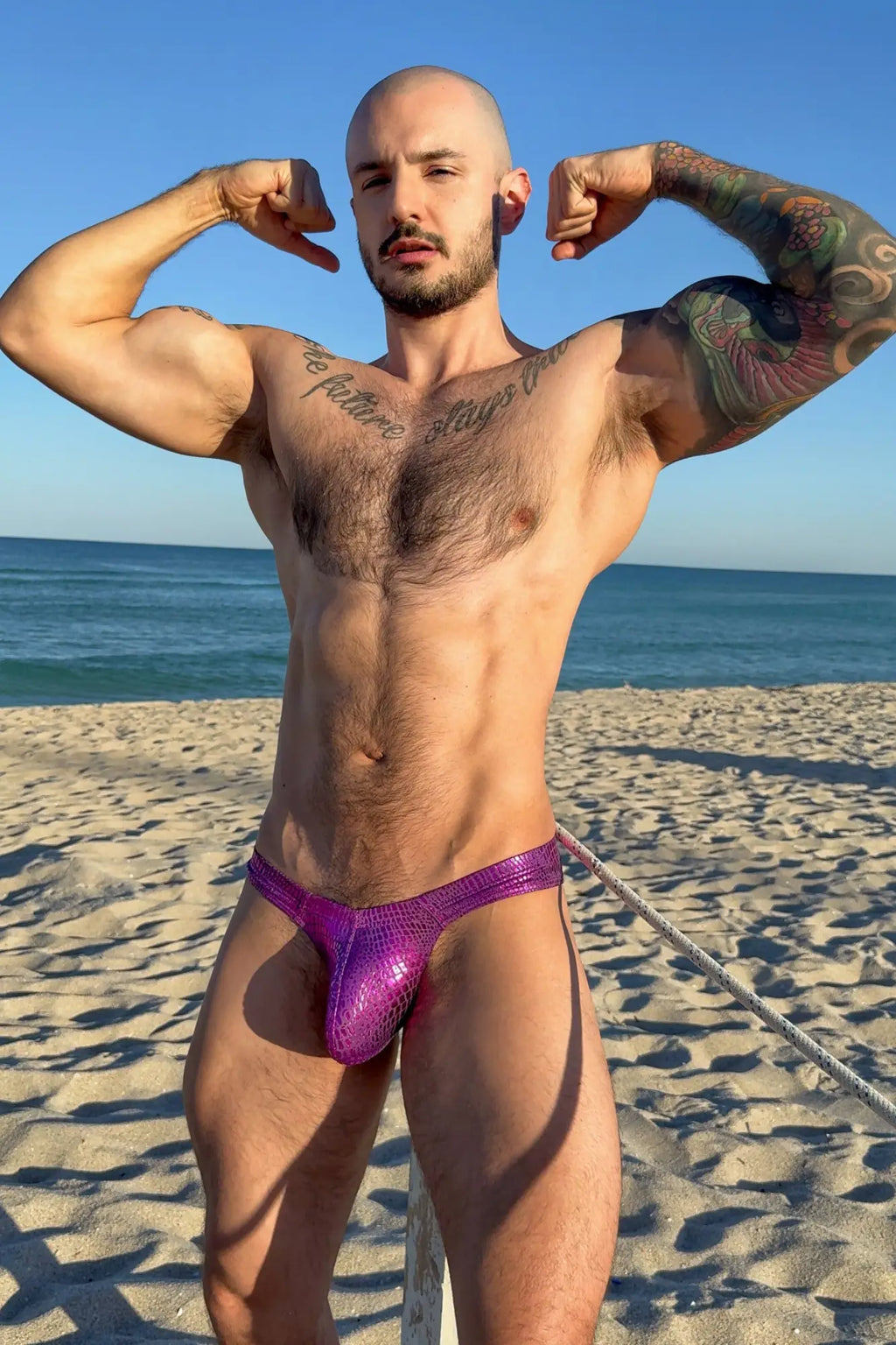 Metallica men’s thong with bulge pouch in vibrant purple shiny snakeskin-patterned swim trunks style