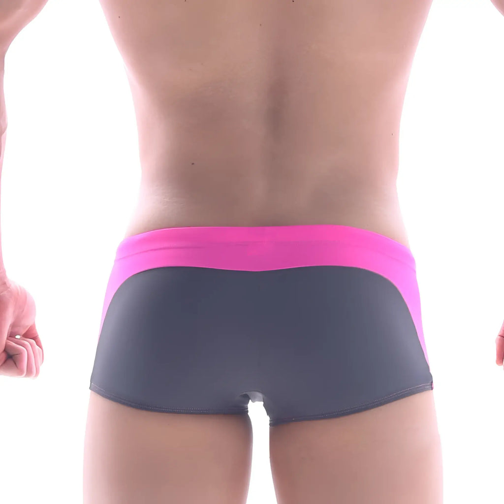 The back of a pair of metrmalewear arc swim boxer briefs with a vibrant pink waistband and dark gray body