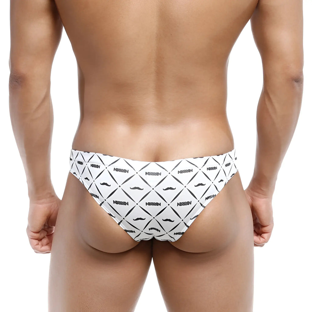 White swim trunks with bold black geometric and mustache patterns featuring nassim branding metroMalewear Capri bikini Caballero 6103-03