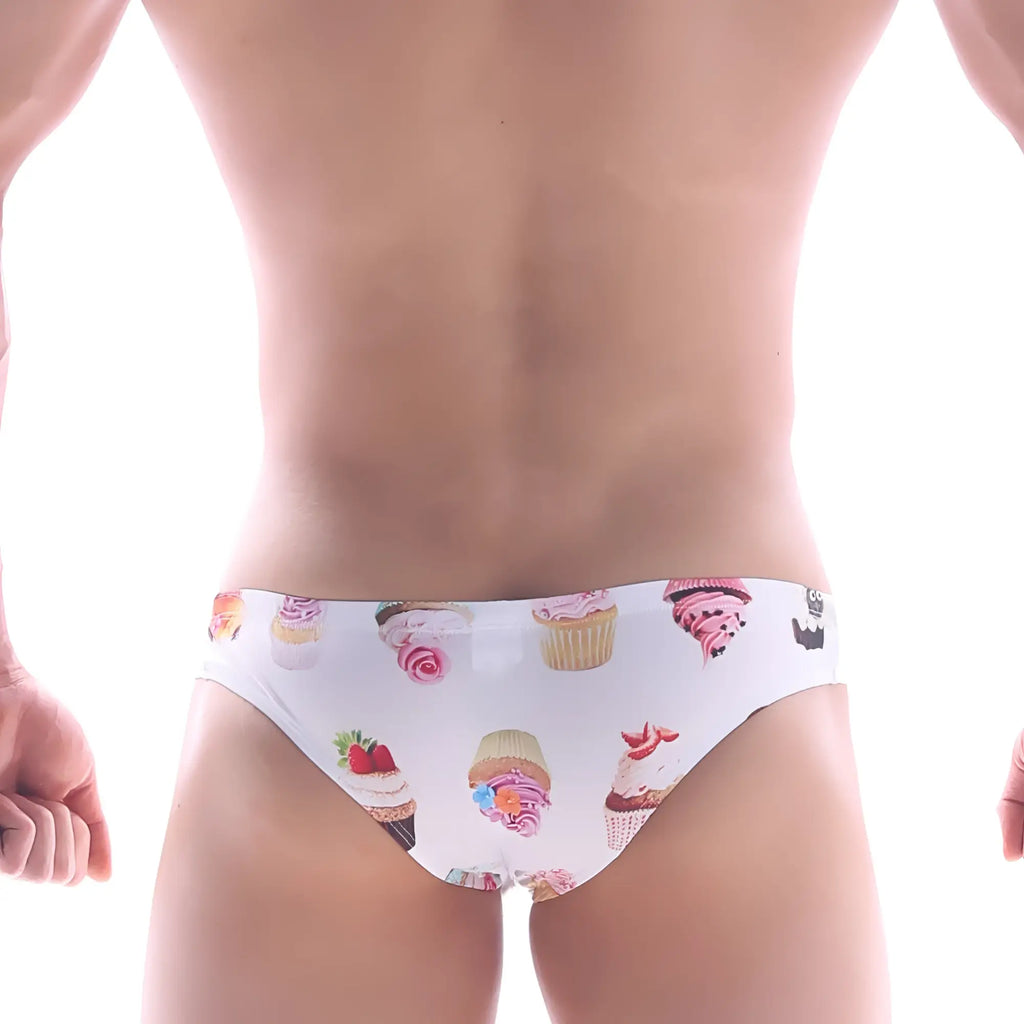 White swim trunks by metromalewear featuring a playful colorful cupcake pattern and frosting designs for beachwear
