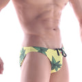 Yellow swim trunks with green leaf patterns and black drawstrings from metromalewear classic swim bikini collection