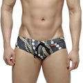 Black swim trunks metroMaleWear classic swim brief Rico 4914-95 with bold gold and white chain-link pattern and drawstring