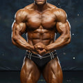 A muscular man wearing black MetroMaleWear Duque swim briefs with silver trim and a form-fitting design