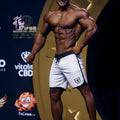 White athletic board shorts with black trim and shield logo on left leg from metromalewear avalanch physique line