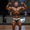 A muscular man wearing black and white metro muscle trunk competition briefs designed for performance and style