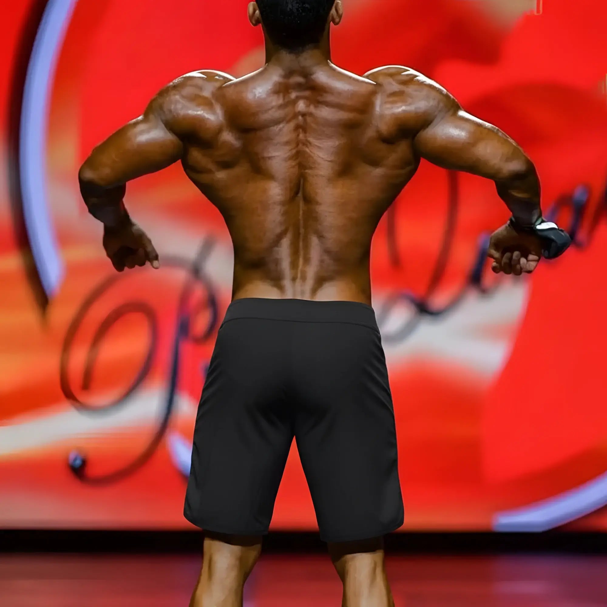 A muscular man’s back showing defined shoulder blades and toned spine wearing metromalewear mens physique board short