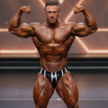 A muscular man wearing metroMalewear metroMuscleWear black and white striped competition briefs for bodybuilding