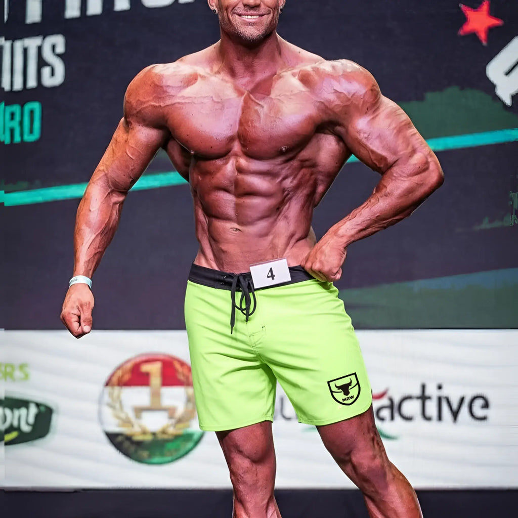 Bright neon green MetroMaleWear Physique board shorts with black waistband drawstring and shield logo on left leg