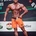 MetroMaleWear physique board short orange with black waistband and drawstring featuring shield logo on lower right leg