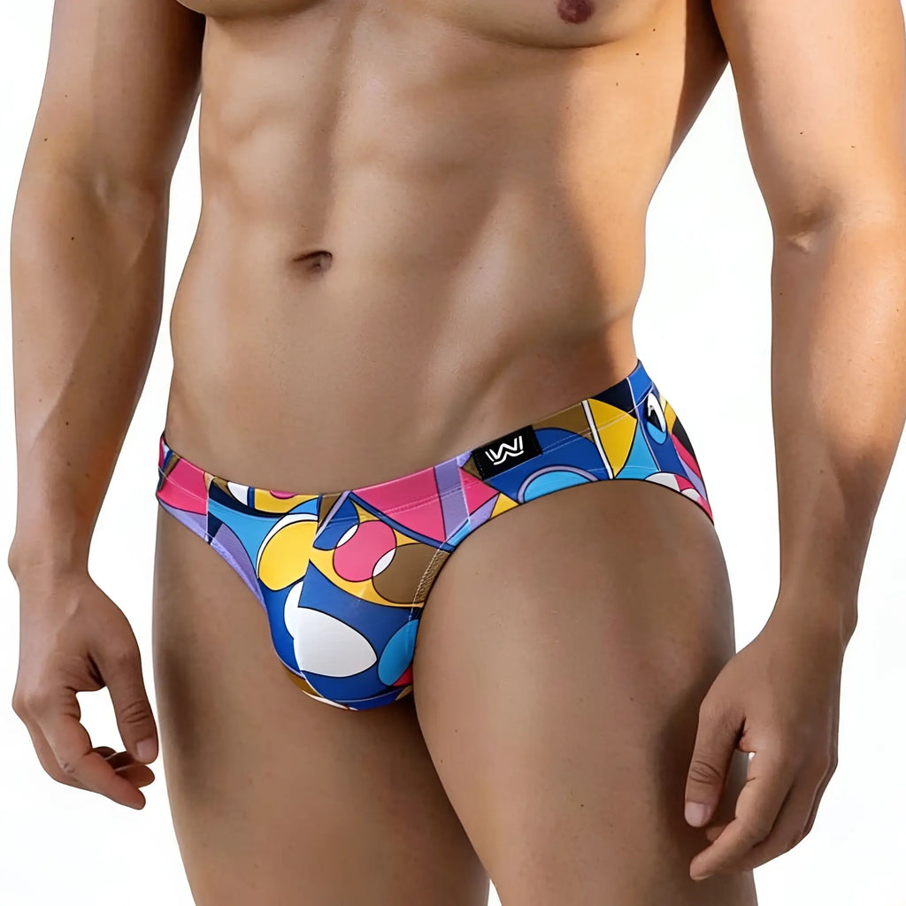 Vibrant geometric-patterned MetroMaleWear Picasso bikini 5103-M87 men’s swim trunks in blue pink yellow and white with black logo tag